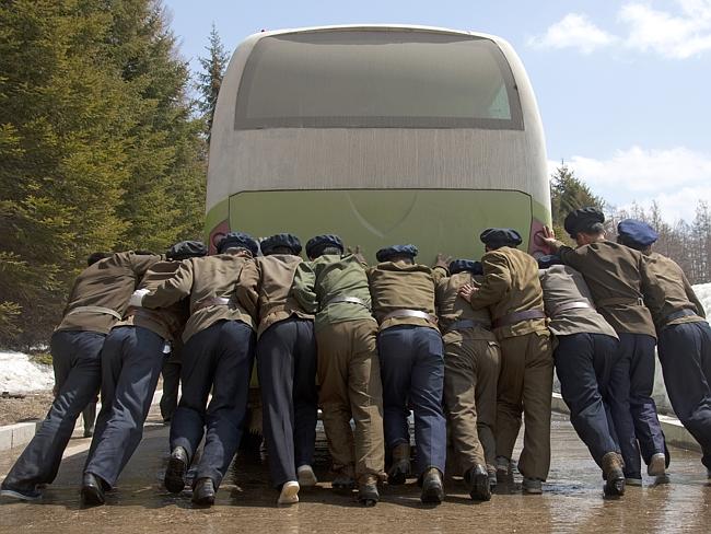 Photos of anything that doesn’t work are forbidden. Here, riders push a broken bus.