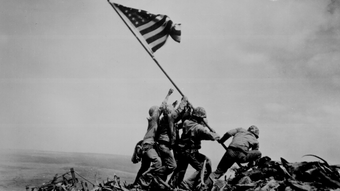 “Raising the Flag on Iwo Jima,” 1945, Mt. Suribachi.
On February 23, 1945, Associated Press photographer Joe Rosenthal shot this photo of five Marines and one Navy corpsman raising a U.S. flag on Mt. Suribachi, the highest point on the Japanese island of Iwo Jima. The battle, one of the bloodiest in Marine Corps history, began on February 19, 1945, when the Americans invaded the heavily fortified island; four days later, they seized it and planted a small flag atop Mt. Suribachi. However, later that same day, the flag was ordered replaced with a much larger one that could be seen by troops across the island and on ships offshore. Rosenthal’s photo shows this second raising of the Stars and Stripes. The combat photographer subsequently was accused of staging the dramatic picture, but he denied the charge and eyewitnesses backed him up. The widely reproduced photo became a powerful patriotic symbol and went on to win a Pulitzer Prize and serve as the model for the Marine Corps War Memorial near Arlington National Cemetery.
Three of the Marines in the photo were killed in action on Iwo Jima (the battle didn’t officially end until March 26, 1945), while the three surviving flag-raisers were sent back to the U.S., where they were treated as heroes and appeared at rallies across the country to promote the sale of war bonds.