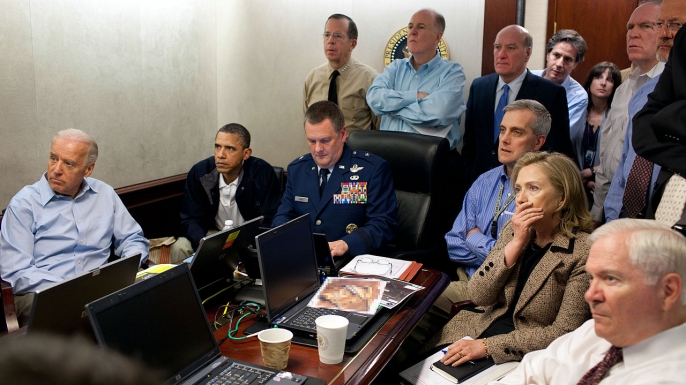 “The Situation Room,” 2011, White House.
Taken on the afternoon of May 1, 2011, this image shows President Barack Obama and his national security team receiving updates about the top-secret Navy SEAL raid on the Pakistani compound of one of the most-wanted men in U.S. history, al-Qaeda leader Osama bin Laden. At 11:35 ET that night, the president appeared on live TV to announce that the mastermind behind the 9/11 terrorist attacks had been killed by the SEALs.
White House photographer Pete Souza snapped the photo after Obama and his senior aides had crowded into a small conference room in the West Wing’s Situation Room complex, where Brigadier General Marshall “Brad” Webb was monitoring the mission. When Obama entered the room, Webb offered the president his chair. However, as Obama told NBC News, “ I said, ‘You don’t worry about it. You just focus on what you’re doing. I’m sure we can find a chair and I’ll sit right next to him.’ And that’s how I ended up [on a] folding chair.” Obama later referred to the high-stakes raid, during which a SEAL helicopter crash-landed at bin Laden’s hideout, as the longest 40 minutes of his life, while Secretary of State Hillary Clinton said she’d been concentrating so intensely while monitoring the raid that she hadn’t been aware the White House photographer was taking pictures.