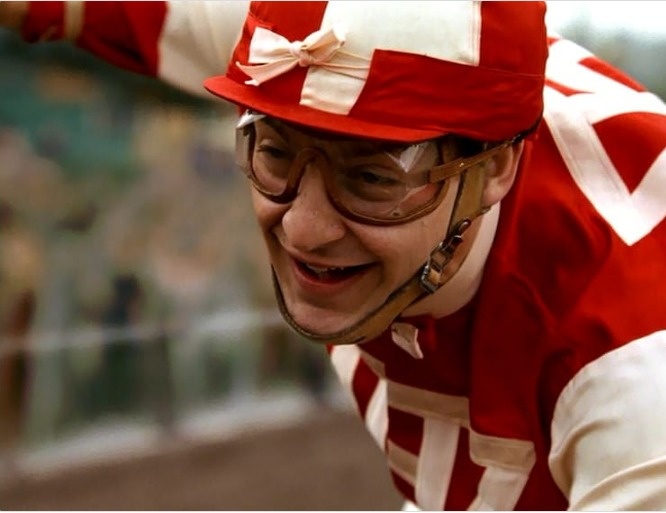 Seabiscuit.
Seabiscuit is based on the true story of a small horse by the same name during the Great Depression. In the movie, the jockeys like Tobey Maguire wear plastic lenses and chinstraps attach to their hats. The lenses began to be used after WWII and the straps were not introduced until 1956.