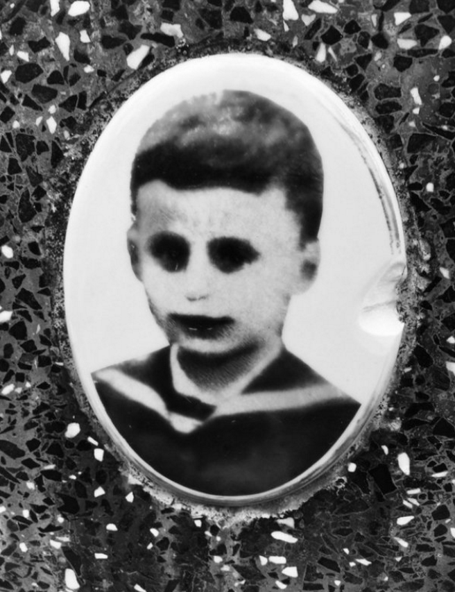 A faded porcelain picture on a grave.