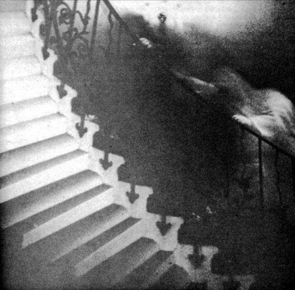 The Staircase Ghost.
Reverend Ralph Hardy, a retired priest from White Rock, BC took this photo in 1966. The original intent was to take a picture of the gorgeous Tulip Staircase in the Queen’s House section of the National Maritime Museum in Greenwich, England, but he caught more than that. After developing the photo and having it verified by experts, he found that he captured the image of a shrouded figure, climbing the stairs. Apparently the stairs are rumoured to be haunted, with strange happenings and unexplained footsteps to it’s credit.