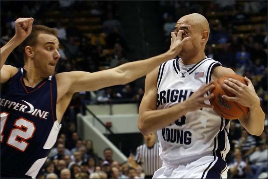 Pepperdine’s Jason Walberg, #12, gouges the eyes of Brigham Young University’s Jonathan Tavernari, #45, during the first half of the game. No foul was called on the play.