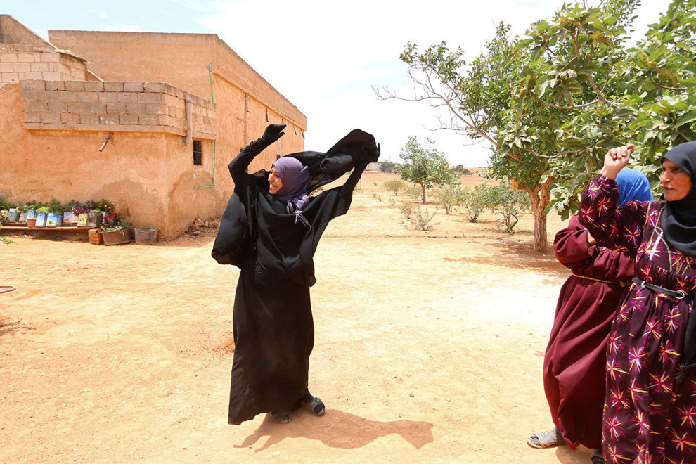 Souad Hamidi excitedly removing the niqab she has been forced to wear since 2014, after the Syrian Democratic Forces took control of her village.