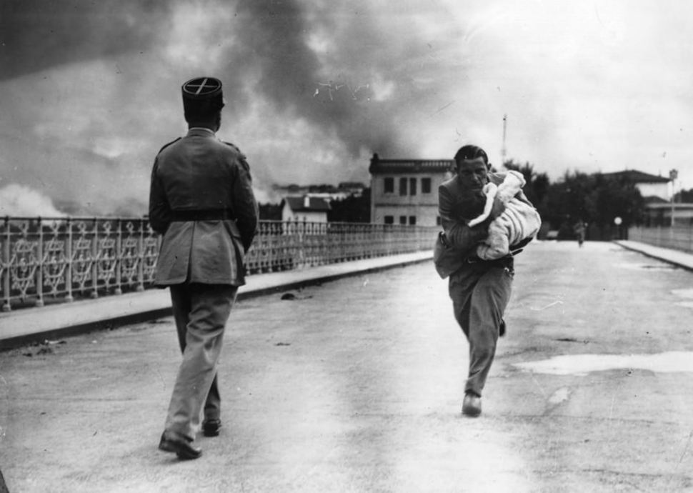 A journalist sprinting across a bridge in attempts of rescuing the baby in his arms during the Civil War in 1936.