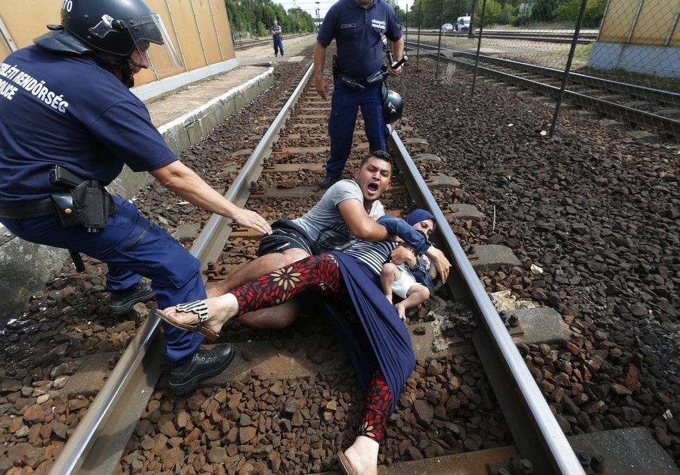 Migrants refusing to be removed from the tracks at a railway station in Bicske by Hungarian policemen.