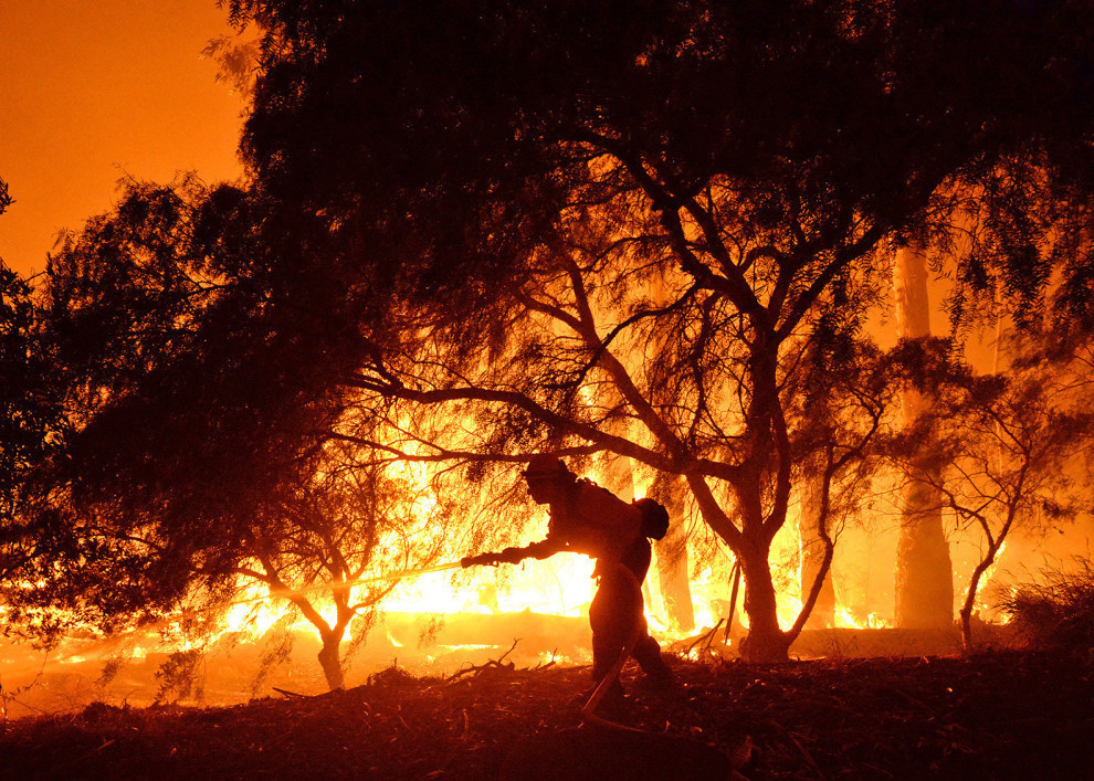 A fire fighter battling the ferocious flames near Las Flores Canyon as they began approaching a nearby ranch.