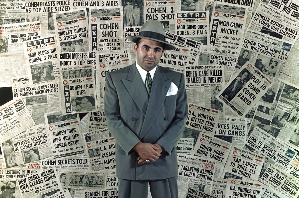 Gangster Mickey Cohen standing amongst the front pages of newspapers that helped make him the city’s’ most infamous citizen – 1960