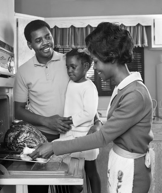 In 1960 a family looks at the turkey being removed from the oven. They look pretty happy that it's ready to eat.
