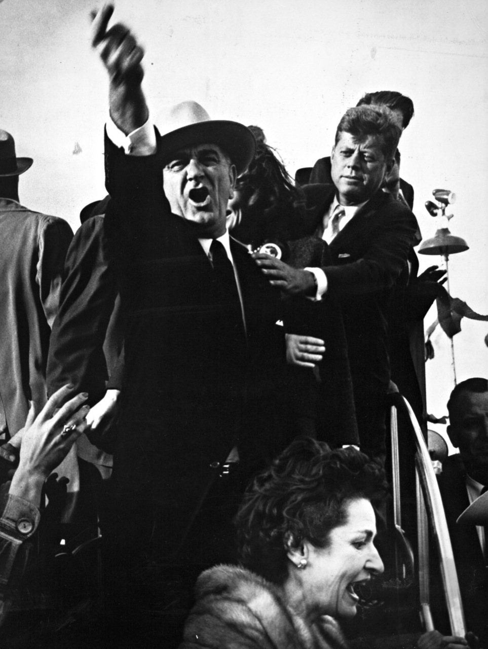 Lyndon B. Johnson yelling at the pilots of a nearby plane to cut their engines so that John F. Kennedy could speak as Kennedy is seen trying to calm him down. Taken during the 1960 presidential campaign in Amarillo, Texas