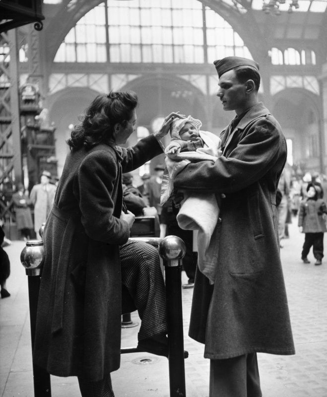 An American soldier says goodbye to his wife and infant child in Pennsylvania Station before shipping out for service in World War II. New York City,1943