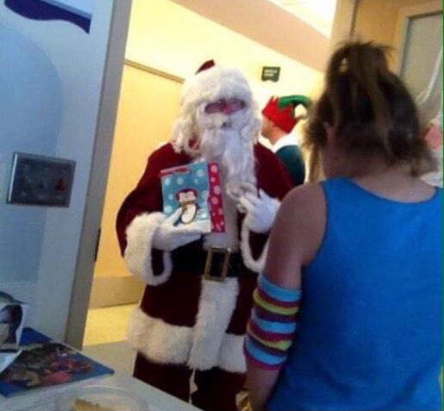 George W. Bush, dressed as Santa, visiting children in hospital. Secret Service dressed as elves