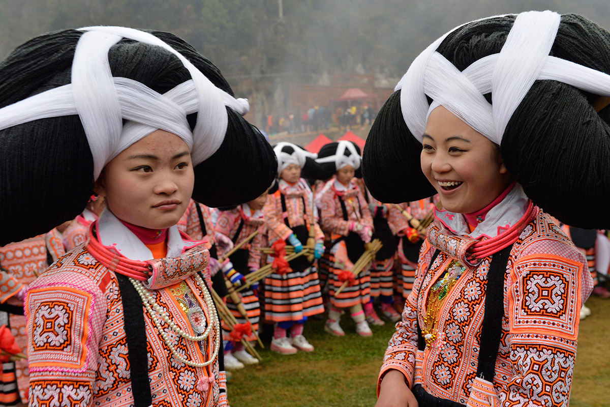 Girls of China’s Long-horn Miao tribe wear huge head dresses made from the hair of their deceased ancestors, Guizhou, China