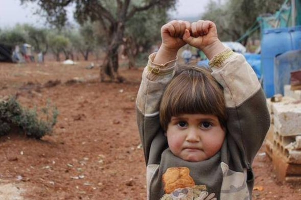 A Little Syrian girl mistakes camera for gun and immediately surrenders instead of smiling.