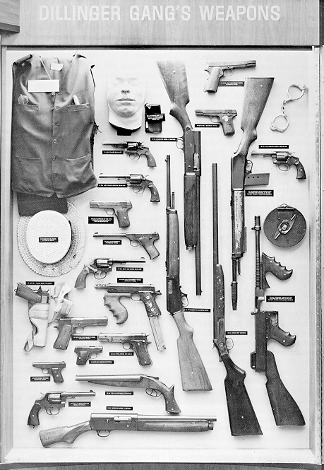 This photograph was taken at FBI headquarters in Washington DC.. It shows the weapons that were used by the Dillinger Gang.
Note the modified Colt government model M1911A1 pistol in caliber .38 Super in the lower left portion of the photograph. It has been modified to use a Colt Thompson vertical foregrip, extended box magazine, and fired fully automatic.