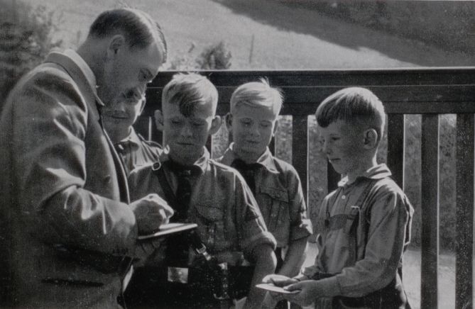 Adolf Hitler signing autographs for some Hitler youth children sometime in the 1930’s