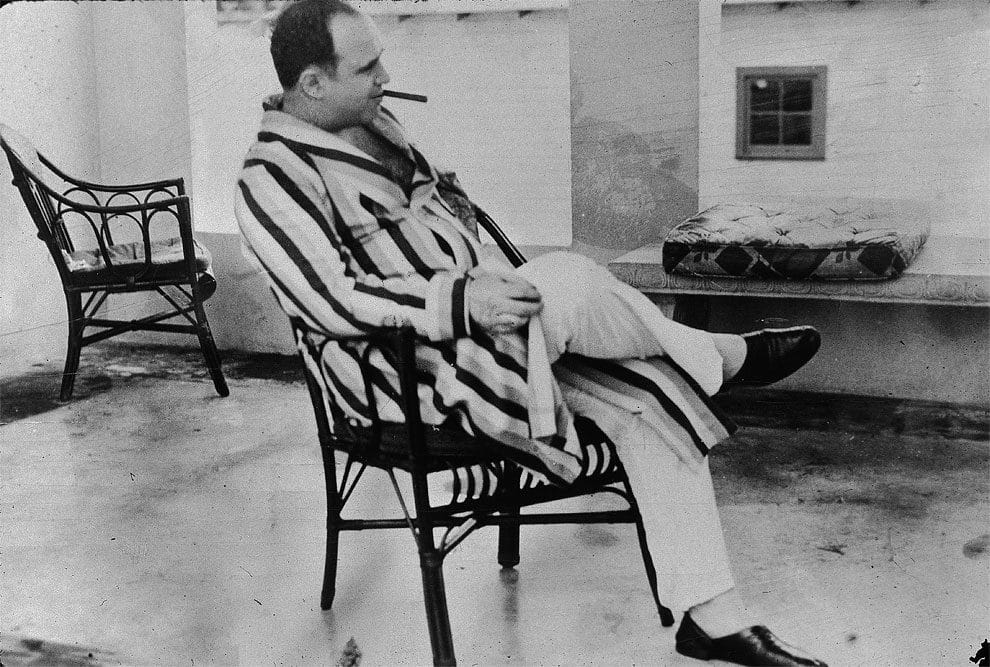 American gangster Al Capone (“Scarface”) (1899 – 1947) relaxes in his vacation home, Miami, Florida, 1930. Capone smokes a cigar and wears a striped dressing gown and slippers