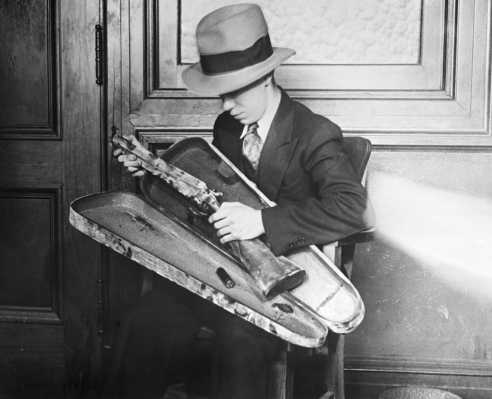 This sawed-off shotgun was carried in a violin case to the Port Newark National Bank in Newark, NJ on February 28, 1930. Three gunmen – determined to seize $25,000 – staged a wild west gun battle at the entrance of the bank in the center of the city, at 10:45 A.M. Osie Danneman, black messenger for the bank, was the hero, saving $25,000. Photo shows the violin-cased sawed-off shotgun
