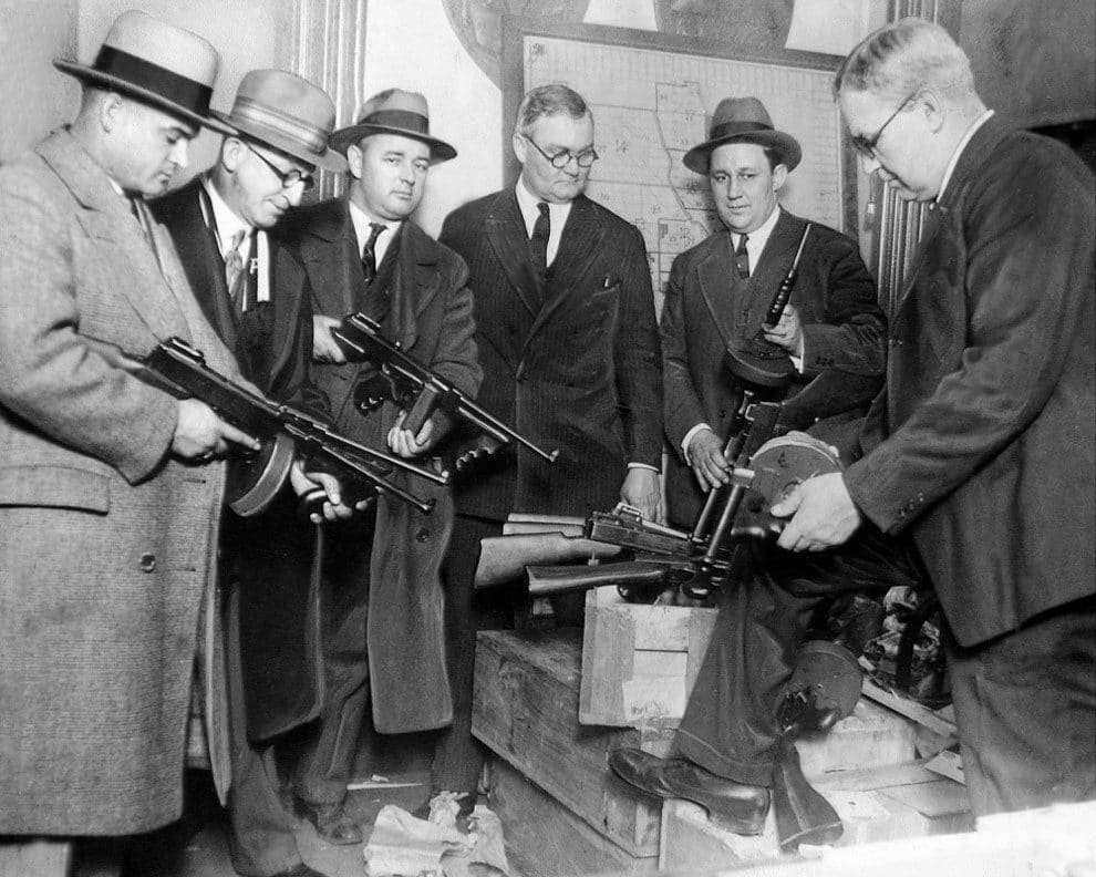 Primed for warfare, Chicago gangsters forced police to equip themselves with miniature arsenals to cope with gang wars. Deputy Chief Stege (right) hands out machine guns to detectives while Chief of Detectives Shoemaker (fourth from left) looks on, January 09, 1927