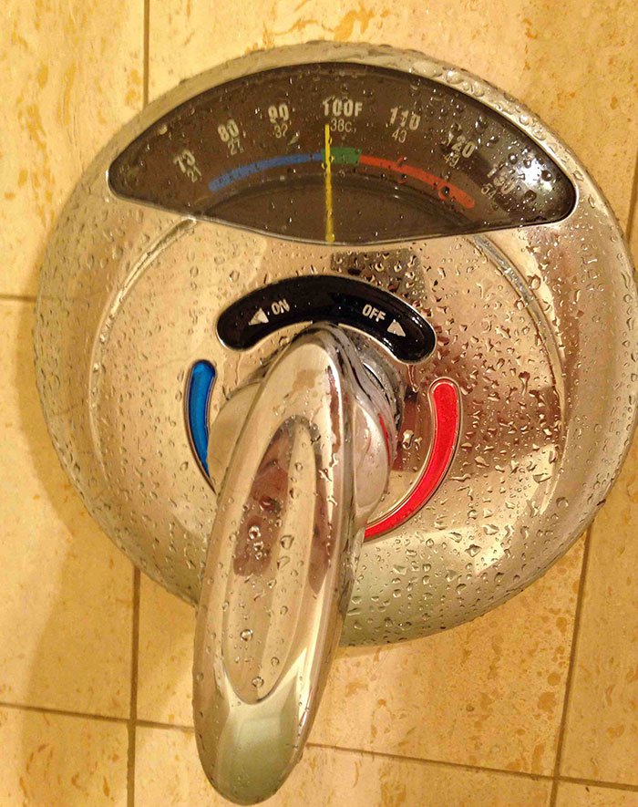 Shower handle with a thermometer for water temperature.