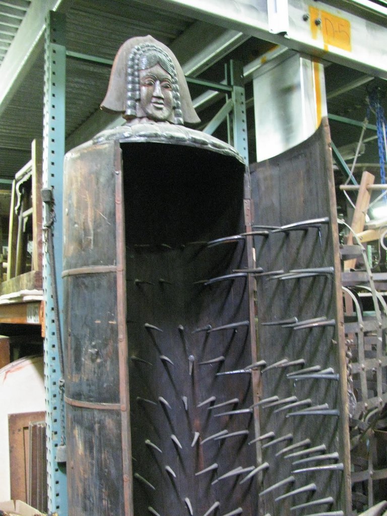IRON MAIDEN.

This torture device consisted of an iron cabinet with a hinged front and spike-covered interior, sufficient enough to enclose a human being. Once inside its conical frame, the victim would be unable to move due to the great number of steel spikes impaling them from every direction. The interrogator would scream questions at the victim while poking them with jagged edges.