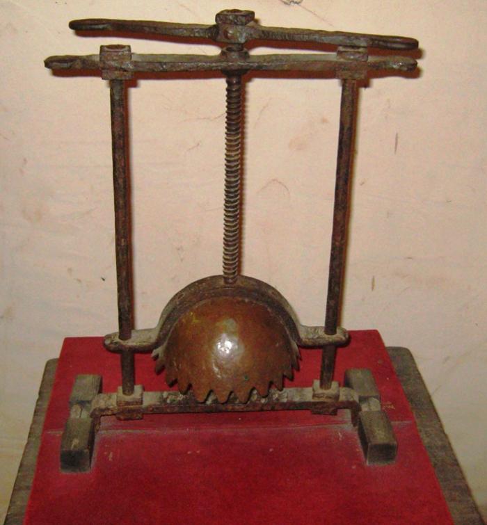 HEAD CRUSHER. 
This metal device featured a plate that sat below the victim’s jaw, which was connected by a frame to the head cap. As the torturer slowly twisted the handle, the gap between the head cap and plate decreased in width, causing crushing of the skull and facial bones, including teeth and jaws, and ultimately inducing death; even if the torturer stopped before death, permanent damage to the facial muscles and structure would occur. The victim’s head would slowly be crushed, killing the victim, but not before the victim’s jaw had been crushed, and their eyes had popped from their socket.