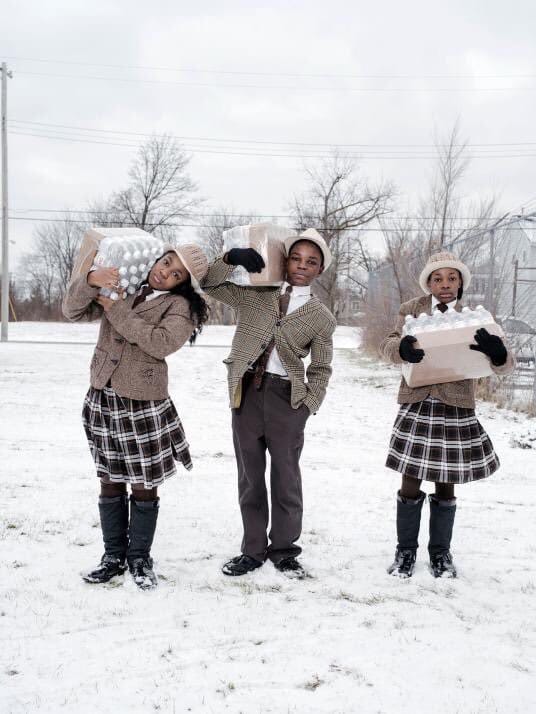 3 siblings picking up their daily allowance of bottled water from the Fire Dept in Flint, MI