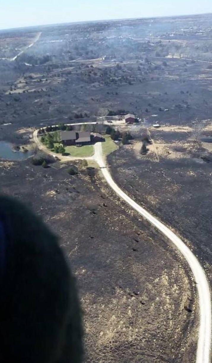 Homeowner turned his sprinklers on before leaving to escape a Kansas wildfire. He came home to this (photo by the Kansas Air National Guard)