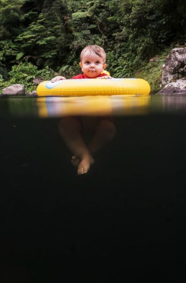 baby floating above dark water