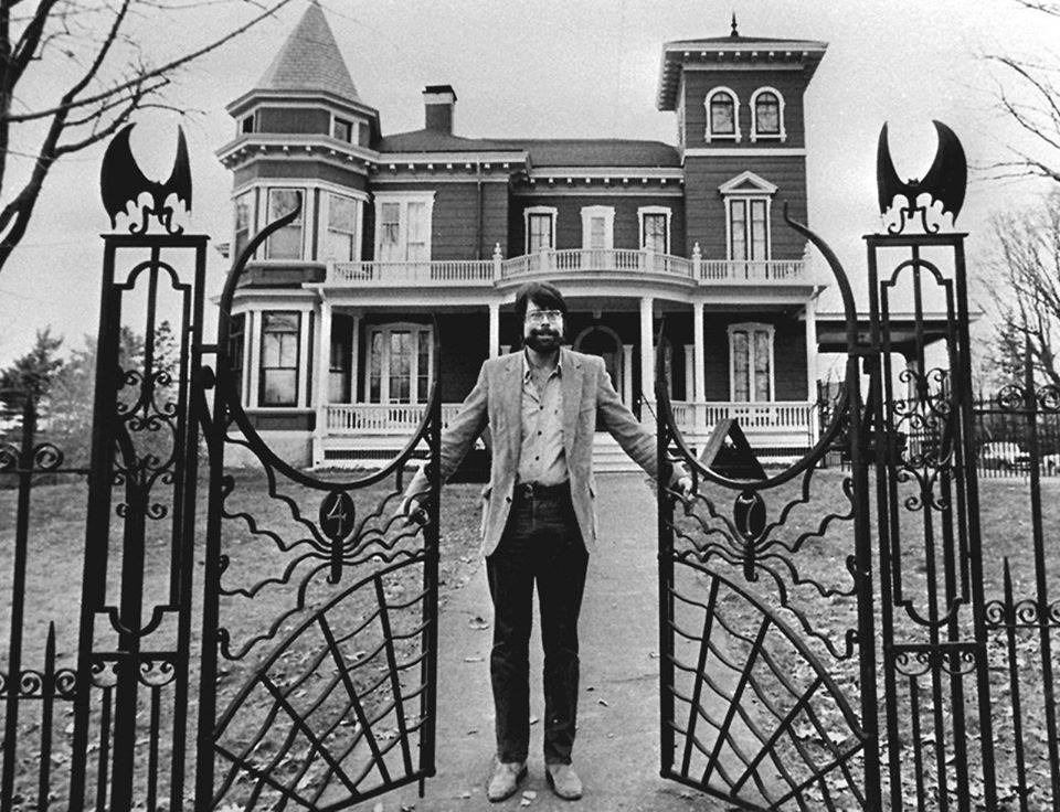 Stephen King standing at the gate of his house in Bangor, Maine