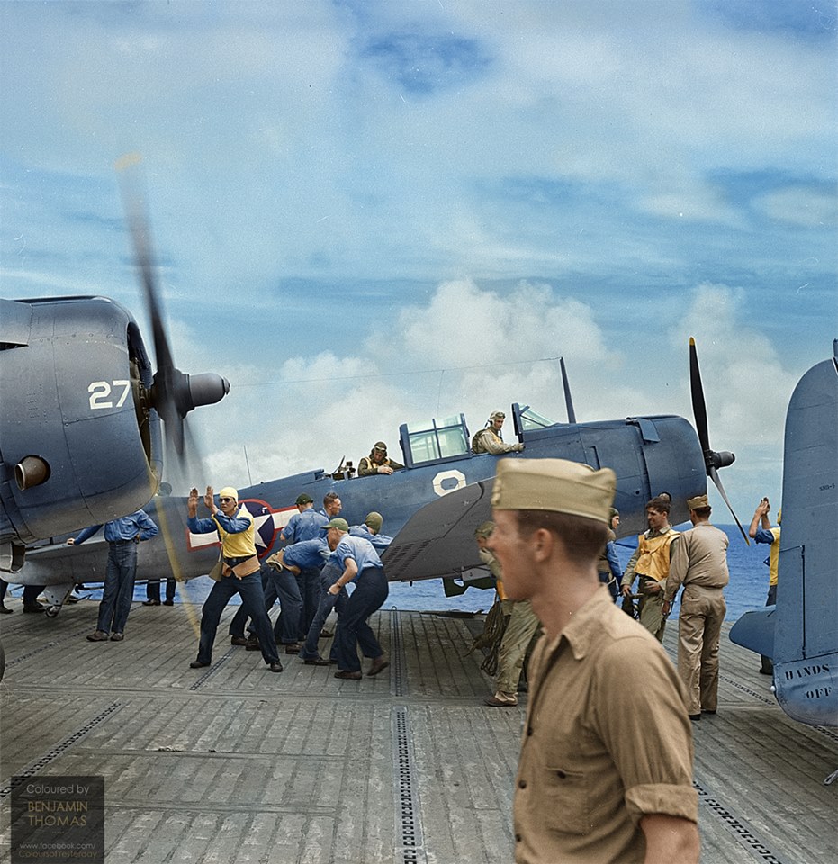Flight deck crews spot Douglas SBD-5 Dauntless dive bombers of bombing squadron VB-12 which have just returned from an attack on Japanese-occupied Pacific islands to the flight deck of the US Navy aircraft carrier USS Saratoga(CV-3), October 1943.