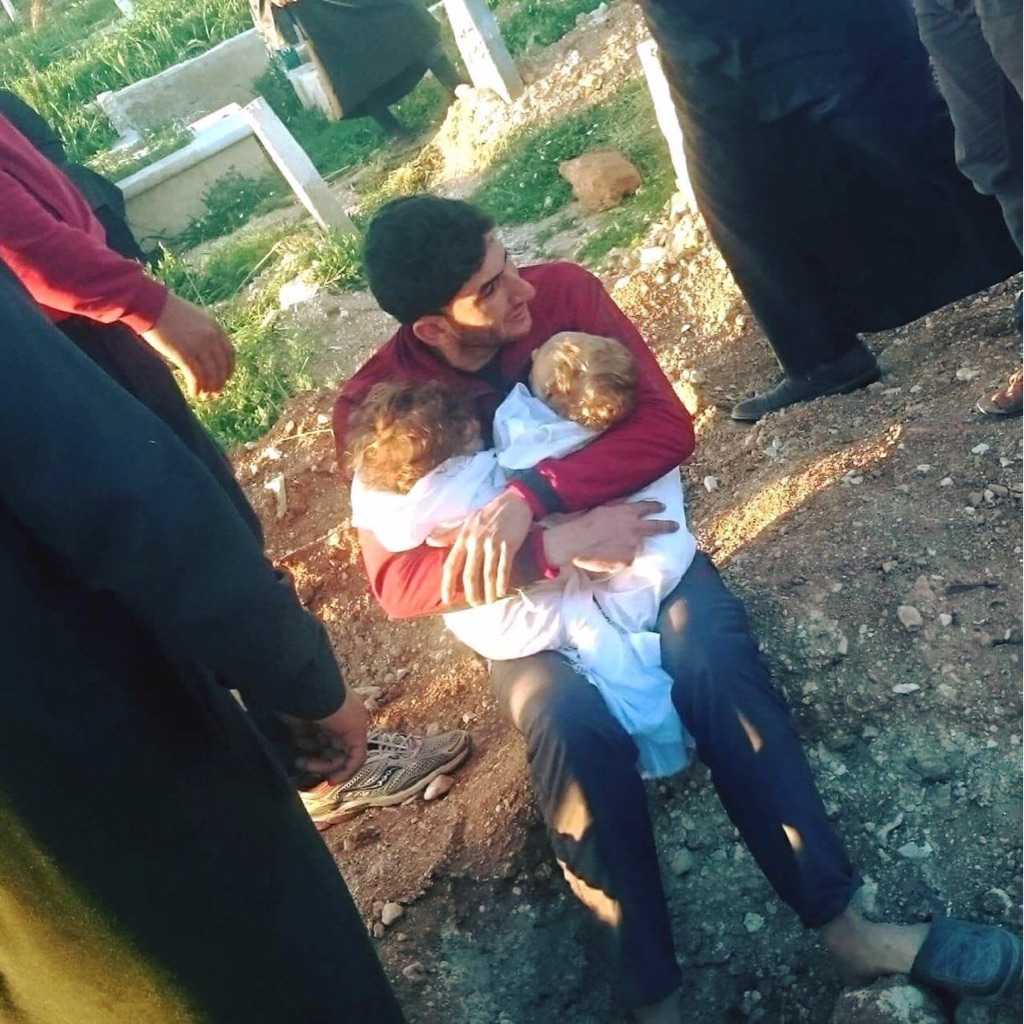 Syrian father holds his dead children after sarin gas attack