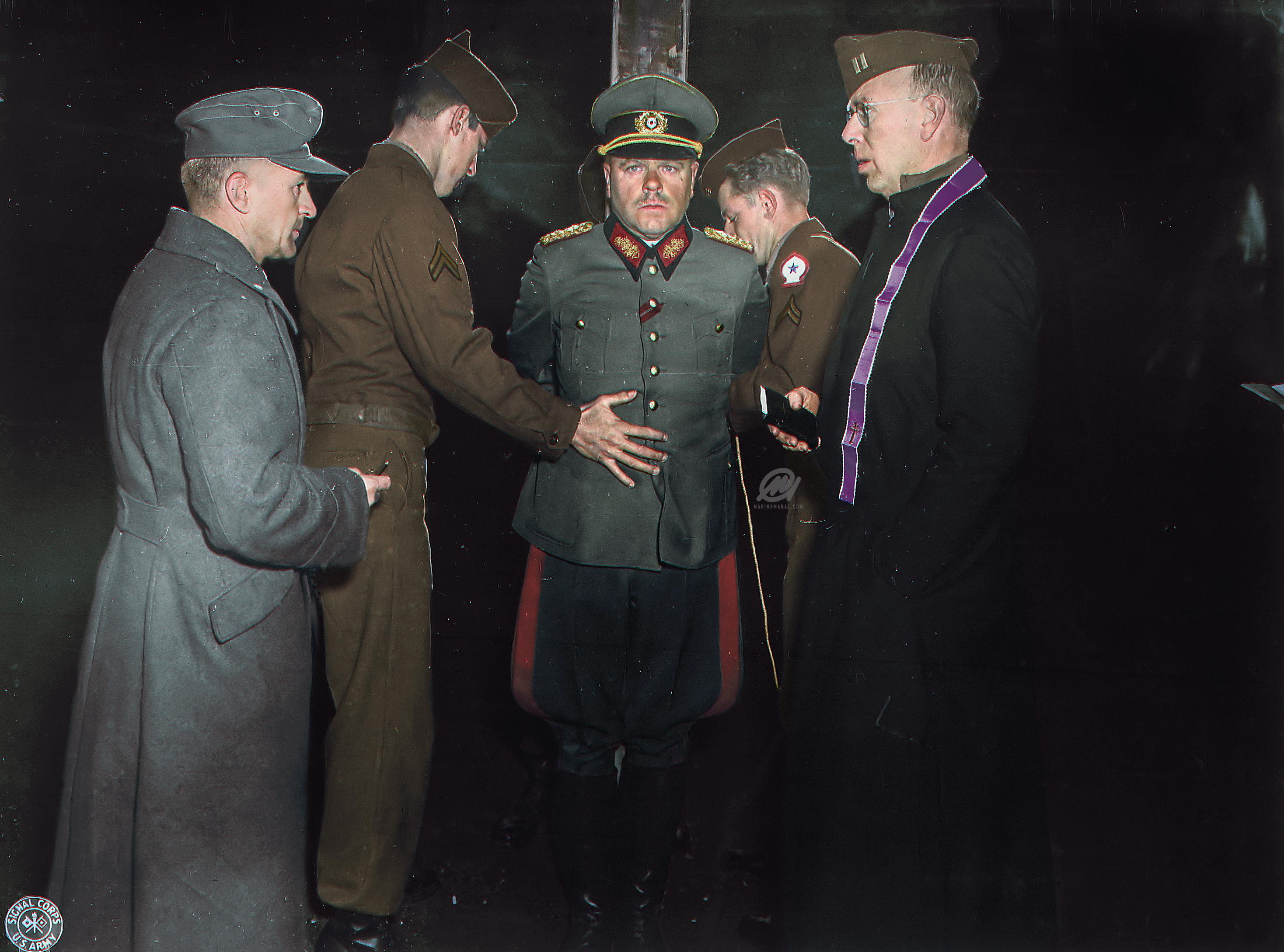 American troops prepare nazi Major General Anton Dostler for execution for killing 15 OSS men, Italy, 1945.

German General Anton Dostler is tied to a stake before his execution by a firing squad in the Aversa stockade. The General was convicted and sentenced to death by an American military tribunal after ordering the execution of 15 US soldiers on 26th March 1944.
General Anton Dostler was a general of the infantry in the regular German Army during World War II. In the first Allied war trial after the war, Dostler was found guilty of war crimes and executed by firing squad. He ordered and oversaw the unlawful execution of fifteen captured U.S. soldiers. The soldiers were sent behind the German lines with orders to demolish a tunnel that was being used by the German army as a supply route to the front lines. They were captured and upon learning of their mission, Dostler ordered their execution without trial. The U.S. soldiers were wearing proper military uniforms and carried no civilian or enemy clothing and were in compliance with Hague Convention to be considered non-combatants after their surrender. Under the 1907 Hague Convention on Land Warfare, it was legal to execute “spies and saboteurs” disguised in civilian clothes or enemy uniforms but excluded those who were captured in proper uniforms. Since fifteen U.S. soldiers were properly dressed in U.S. uniforms behind enemy lines and not disguised in civilian clothes or enemy uniforms, they were not to be treated as spies but prisoners of war, which Dostler violated. This order was an implementation of Hitler’s secret Commando Order of 1942, which required the immediate execution without trial of commandos and saboteurs.