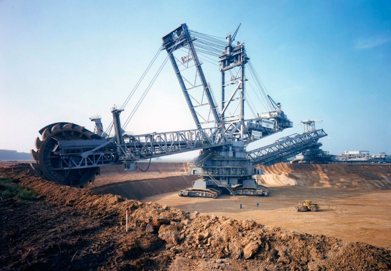 The largest land vehicle ever built: Bagger 293 in Germany.

Deemed the largest land vehicle in history by the Guinness Book of World Records, the Bagger 293 is the single best digging machine man has ever built.
Built in 1995, this bucket wheel excavator is 315 feet tall—dwarfing the Statue of Liberty—738 feet wide and weighs more than 31 million pounds or 15,500 tons. Given all of that size, you’d think it takes a huge crew to run one. But you’d be wrong. Two people run the show.
Its buzz saw-like 70-foot rotating wheel consists of a series of 20 buckets that easily and constantly slice into the earth’s surface, efficiently removing thousands upon thousands of pounds of overburden, the waste soil mining operations need to remove before getting to the coal below.
Once the dirt has been scooped up, it’s transported by the conveyor belt running along the machine’s massive arm to the much smaller dump trucks below that will carry it off.
The Bagger 293 is the largest machine of its kind but has several smaller siblings. The bucket wheel excavator has been around since the 1920s. You can watch two videos of the 293 in action below.
