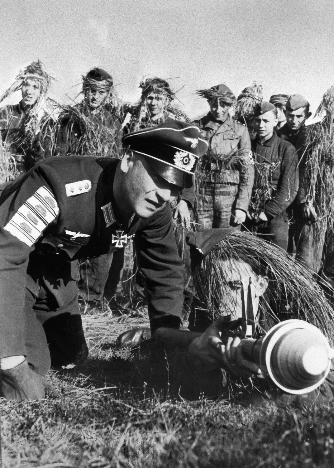 A Wehrmacht veteran teaches Hitler Youth boys how to use a Panzerfaust. The badges on his sleeve represent enemy tanks destroyed.