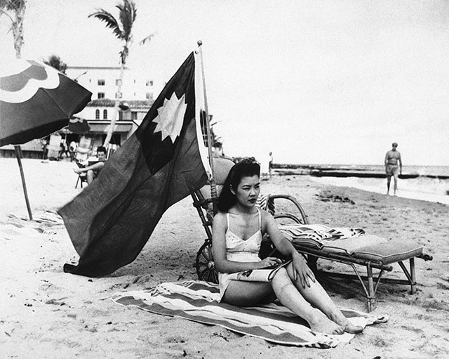 Ruth Lee, a hostess at a Chinese restaurant, flies a Chinese flag so she isn’t mistaken for Japanese when she sunbathes on her days off in Miami, in the wake of the attack on Pearl Harbor, Dec. 15, 1941