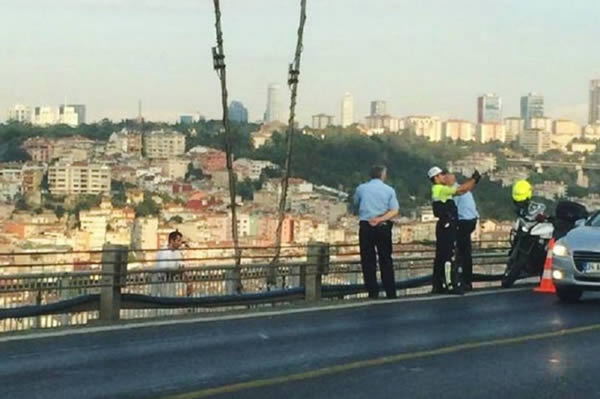A policeman was caught taking a selfie as a man prepared to jump to his death from a bridge. During the desperate man's final moments, the selfie-obsessed cop is seen posing for a snapshot just feet away.

The man is caught in the background of the policeman's shot, clinging to the bridge in the Turkish capital of Ankara. Just seconds later he leaped almost 600ft to his death, after attempts by other officers to talk him down failed.

The picture of the policeman's heartless selfie sparked fury in Turkey, and he now faces an investigation. The 35-year-old man who jumped from the bridge was later identified as Sadrettin Saskn.