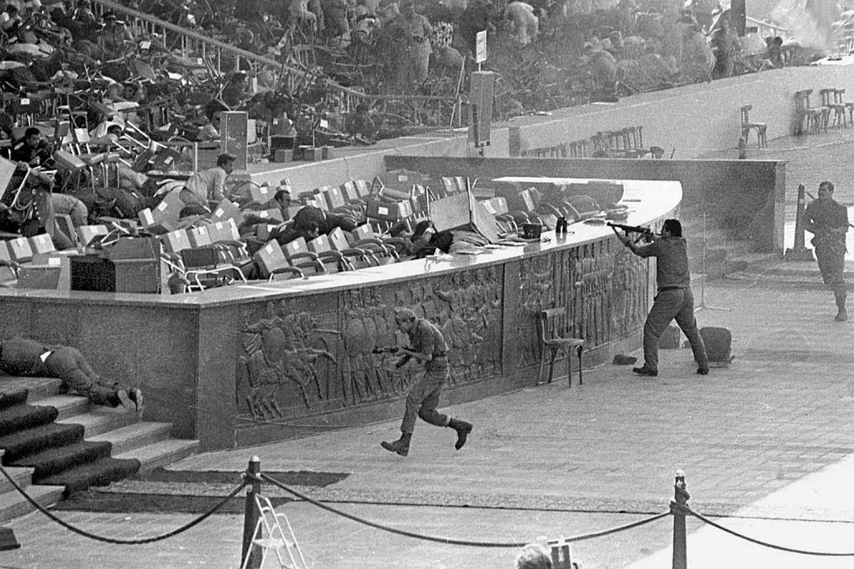 The assassination of Anwar Sadat, 1981.

On 6 October 1981, a victory parade was held in Cairo to commemorate the eighth anniversary of Egypt’s crossing of the Suez Canal. Sadat was protected by four layers of security and eight bodyguards, and the army parade should have been safe due to ammunition-seizure rules. As Egyptian Air Force Mirage jets flew overhead, distracting the crowd, Egyptian Army soldiers and troop trucks towing artillery paraded by. One truck contained the assassination squad, led by Lieutenant Khalid Islambouli. As it passed the tribune, Islambouli forced the driver at gunpoint to stop. From there, the assassins dismounted and Islambouli approached Sadat with three hand grenades concealed under his helmet. Sadat stood to receive his salute. Anwar’s nephew Talaat El Sadat later said: “The president thought the killers were part of the show when they approached the stands firing, so he stood saluting them”. Islambouli threw all his grenades at Sadat, only one of which exploded (but fell short), and additional assassins rose from the truck, indiscriminately firing AK-47 assault rifles into the stands until they had exhausted their ammunition and then attempted to flee. After Sadat was hit and fell to the ground, people threw chairs around him to shield him from the hail of bullets.