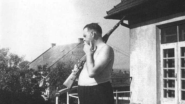 Camp Commandant Amon Goeth, infamous from the movie “Schindler’s List”, on the balcony of his house overlooking Plaszow labor camp. 1943-44

Amon Leopold Goeth the villain of the movie Schindler’s List, was born in 1908 in Vienna, Austria. At the age of 24, he joined the Nazi party. In 1940, Amon Goeth became a member of the Waffen-SS. He was assigned to the SS headquarters for Operation Reinhard in Lublin in German-occupied Poland in 1942. Operation Reinhard was the plan to evacuate the Jews from the Ghettos in Poland to three death camps: Treblinka, Sobibor and Belzec, all of which were in eastern Poland.
In February 1943, Goeth received a promotion and became the third SS officer to hold the job of Commandant of the Plaszow labor camp. While he was the Commandant of Plaszow, Goeth was assigned to supervise the liquidation of the Podgorze ghetto on March 13, 1943, and later the labor camp at Szebnie. The liquidation of the Podgorze ghetto in Krakow is shown in the movie, Schindler’s List.