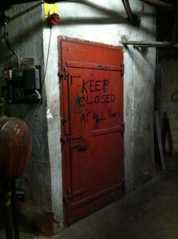 This metal door secured with bolts.
And written on it "Keep Closed At All Times." Don't mind if we do.