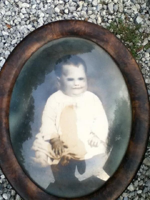 This family found an old photo of a baby.
What was disturbing was that the creepy smile and filled-black eyes.