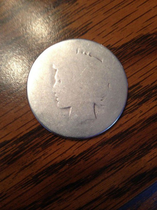 Coin that is almost worn down to not be recognizable anymore.