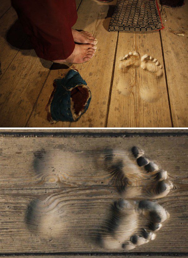 Wooden floor that has been molded to the shape of a person's feet from standing in 1 spot so long.