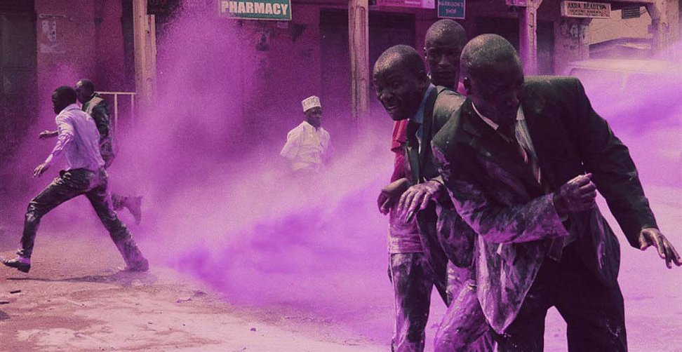Anti-Apartheid protesters sprayed with a water cannon shooting purple dye to mark the demonstrators for arrest. South Africa, 1989