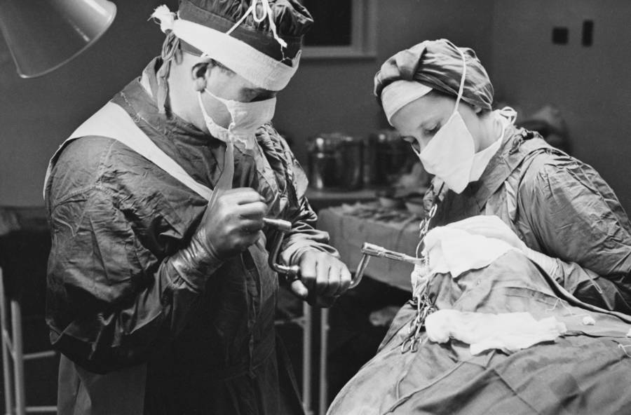 A surgeon uses a brace and bit to drill into a patient’s skull before performing a lobotomy at a mental hospital in England, November 1946.