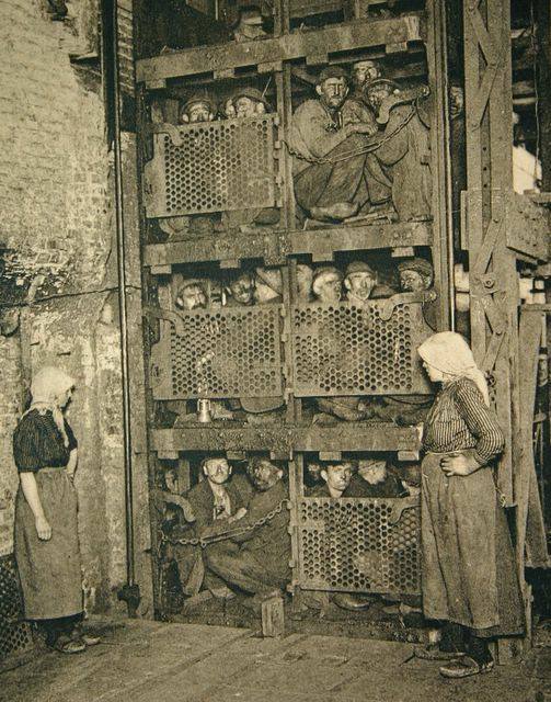 Belgium coal miners crammed into a coal mine elevator, coming up after a day of work, circa 1900.