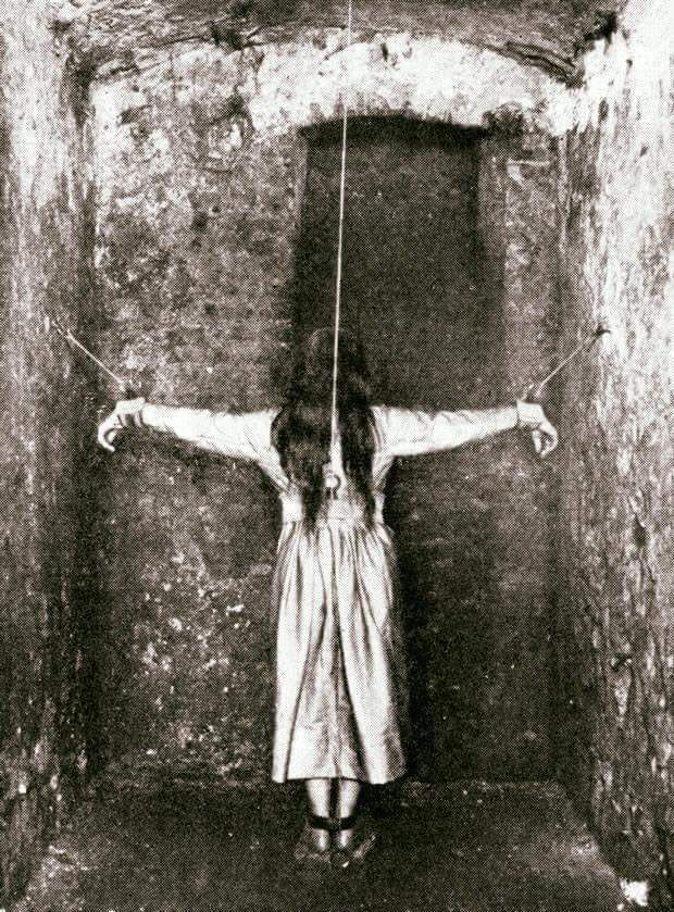Photo from 19th century of forced standing being implemented on a mental patient