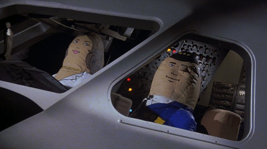 The inflatable co-pilot, Airplane! (1980)
David Zucker, co-director/co-writer: “We had this idea to personify an auto pilot. I think we had an artist draw a conception of it. We modeled it after that kind of cliché image of a pilot [in] comical, blow-up form. The prop department had an air hose that they just blew up in seconds. Then they had it rigged so it would blow up at whatever rate of speed we needed for the scene.
“I don’t remember who specifically came up with the joke. We would sit around the table and think of these things. Jokes were added on as we would write. The hands grabbing her breasts are always a good laugh. When we said, ‘Oh it’s deflating,’ we had her blow it up again, so then the idea was to put the deflator in the guy’s lap… And then how that would look to Leslie Nielsen, who was just happening to enter the cockpit from behind. So all these things kind of all worked. For the ending, somebody, I think a grip, came up with the idea to have a Mrs. Pilot come up. Then he winks and the special effects people rigged all that up.
“I think that my brother, Jerry, may have it in his garage now. The paint has kind of deteriorated a lot because I think it was repainted to be Mrs. Pilot for the end scene.”