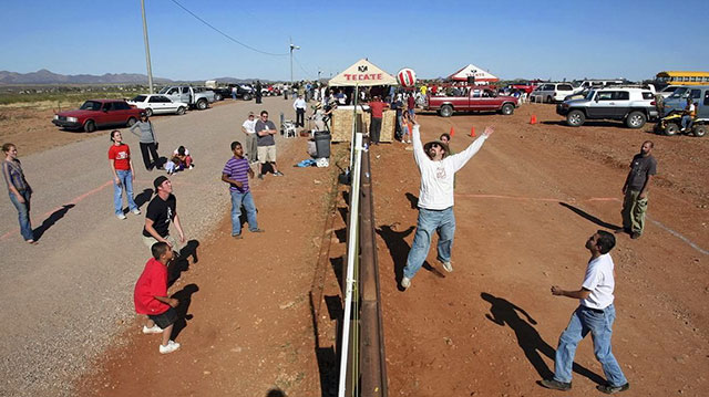 Residents of Naco, Arizona join residents of Naco, Mexico for a volleyball match during the fourth “Fiesta Bi-Nacional” at the fence that separates the U.S. (left) and Mexico (right), on April 14, 2007