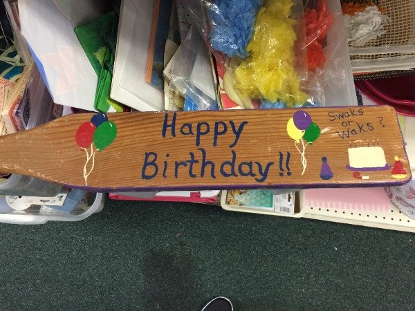 Spanking paddle with the words Happy Birthday painted on it.